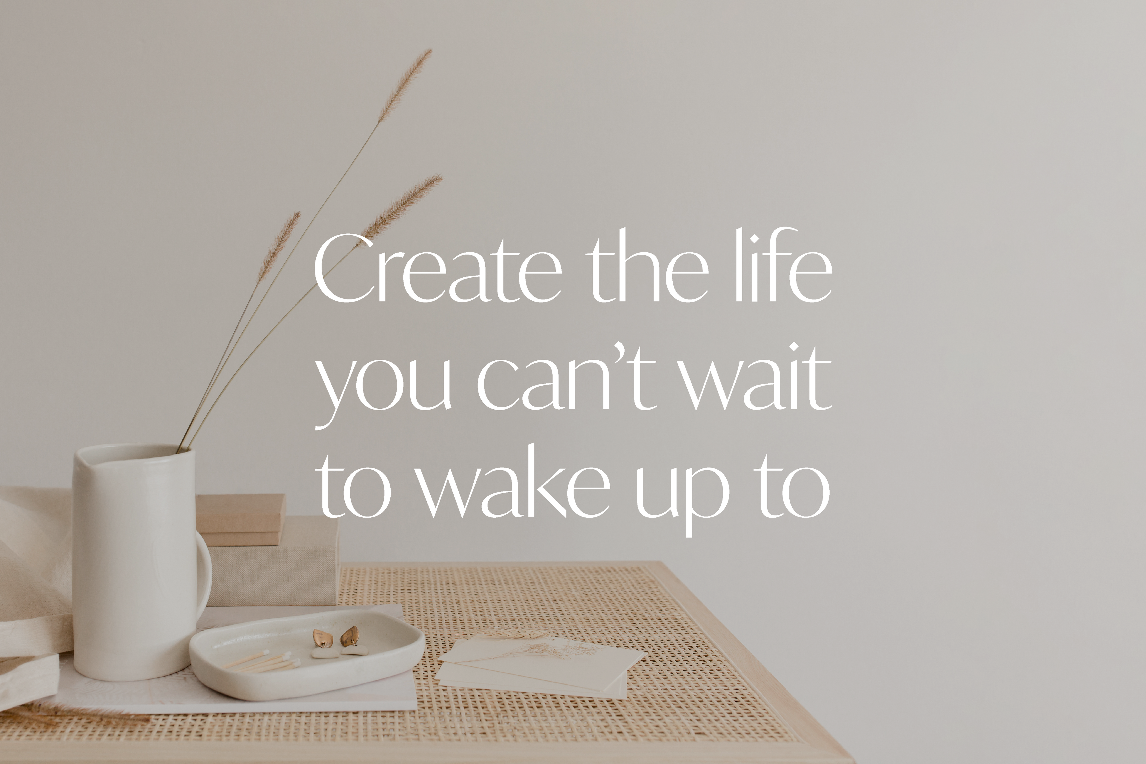 Text "Create the life you can't wait to wake up to" auf verdunkeltem Foto verschiedener Gegenstände in Creme- und Beige-Farben.