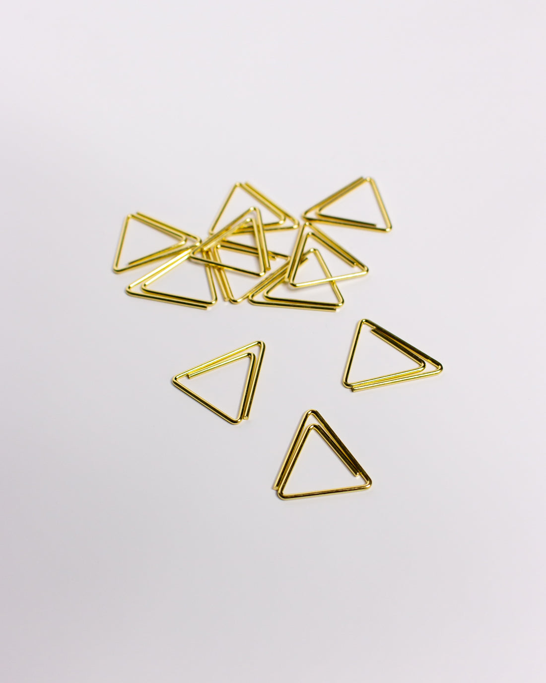 Goldene Büroklammern in Dreiecks-Form