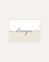 A postcard design reading "I love you" in black cursive writing, that splits the card into two halves. The top half is white and the bottom half is beige. The design is shown on a beige backround.