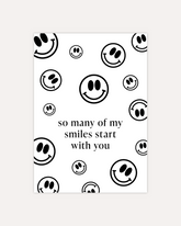 A postcard design consisting of many smiley faces in varying sizes and directions and some text in the middle saying "so many of my smiles start with you". The design is shown on a beige background.