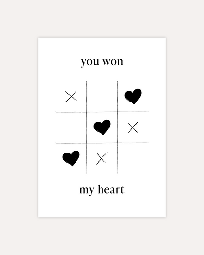 A postcard design showing a game of tic-tac-toe being won with heart symbols. Text saying &quot;you won my heart&quot; is split up with the first two words being above the game and the rest below it. The design is shown on a beige background.